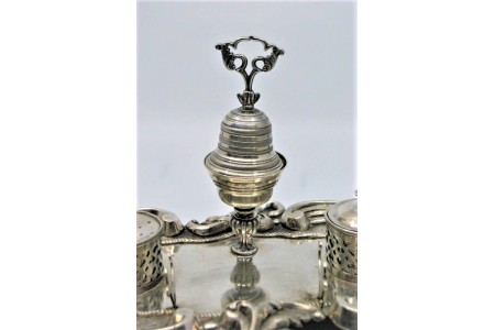 Tinteiro em prata concheada com dois depósitos, campainha e assente em três pés vazados.